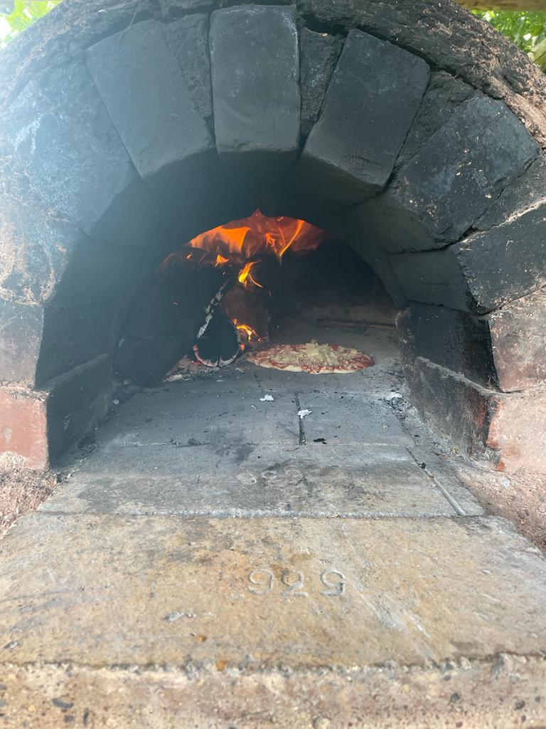 A pizza cooking in the clay oven